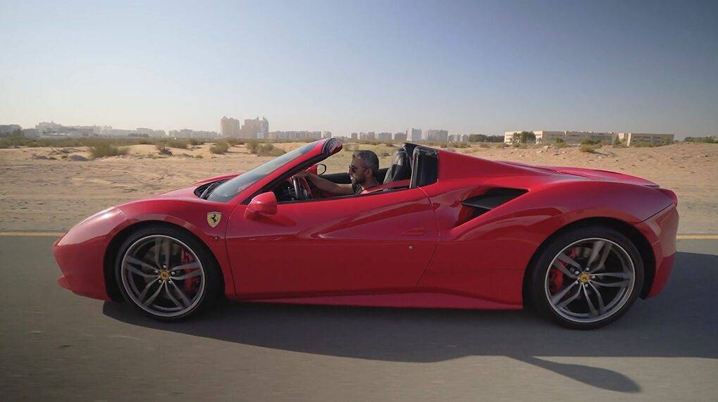 Adeel Chowdhry driving red Ferrari in Dubai