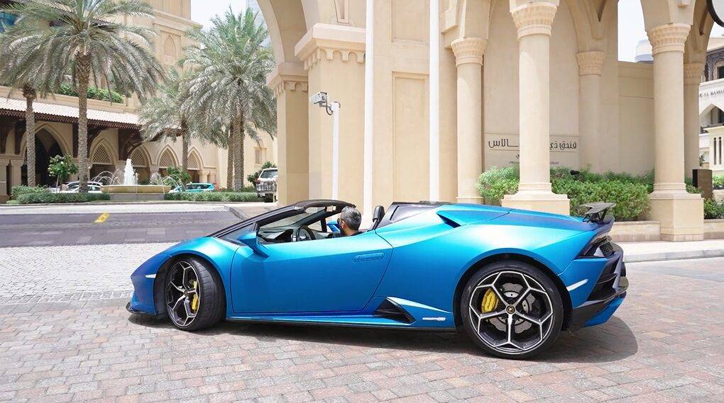 Adeel Chowdhry pulling up to a luxurious Dubai hotel in his blue Lamboghini